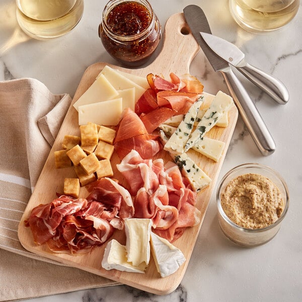 A standard charcuterie board with meat, cheese, and dips