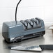 A Mercer Culinary electric knife sharpener sharpening a knife.